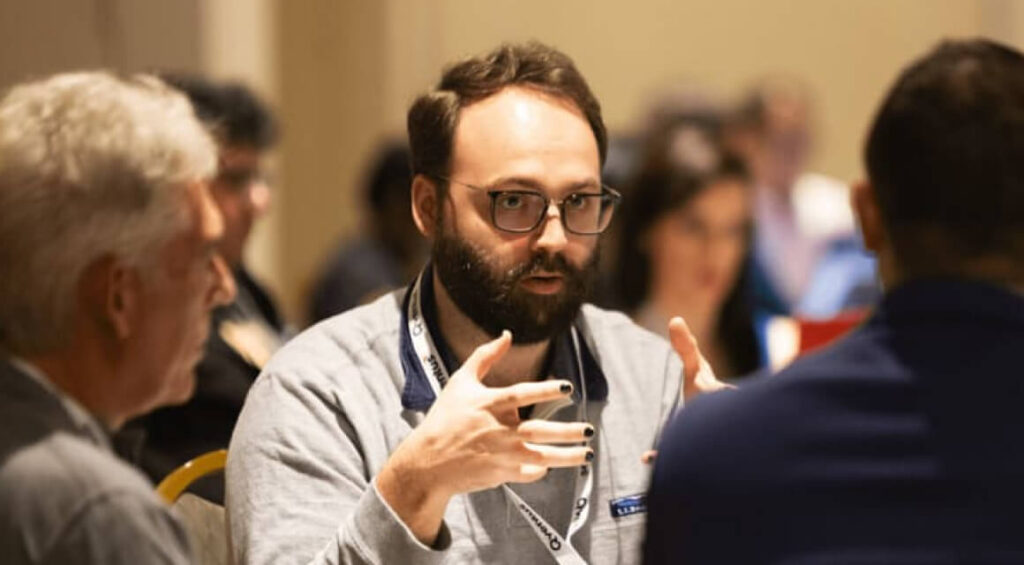 A gallery of photos showing meetings and activities with employees working at Qventus